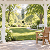 Forest Edge 44-inch Malachite wind chime, original supplier photograph composited in a white garden gazebo with a wooden chair for approximate scale.