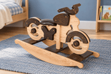 Wooden rocking motorcycle with a cushioned seat shown on a blue rug in a child's room.